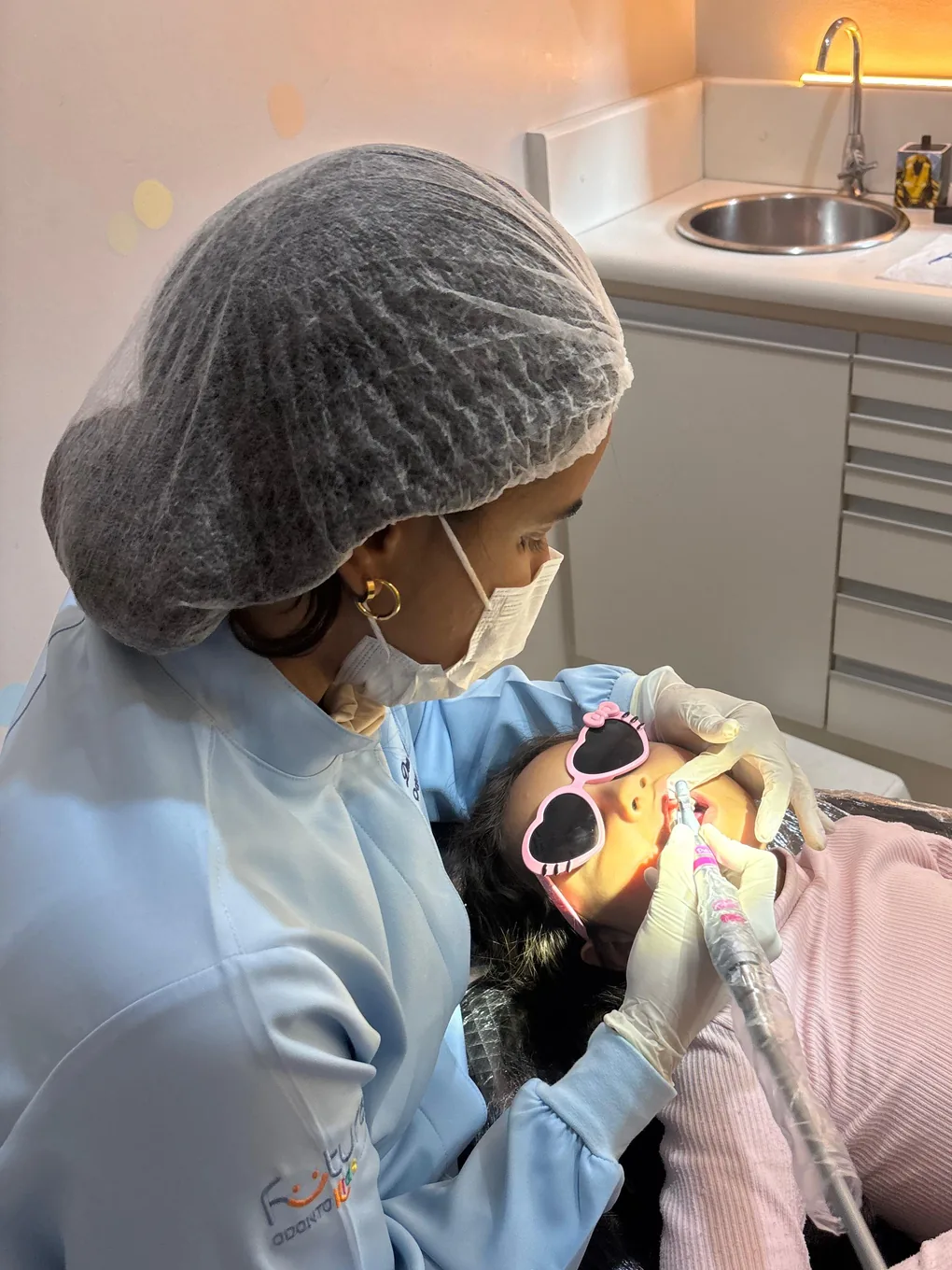 Dra. Renata Paz atendendo uma criança na cadeira odontológica