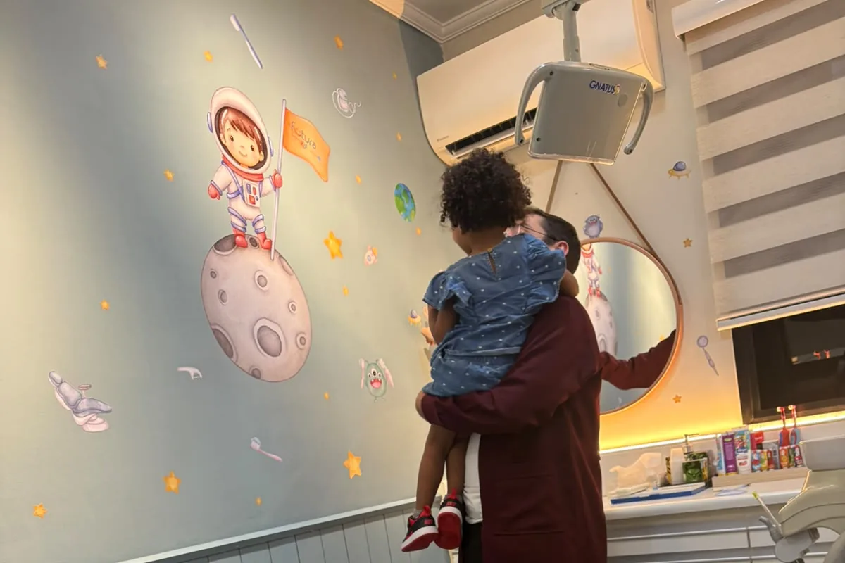 Consultório de odontopediatria com parede temática de astronauta, no Jaguaré